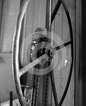 Black & White Photo of Metal Spoke Hand Wheel On Machine