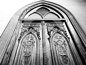 Old and tall massive wooden door, in the entrance of a cathedral photo
