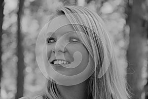 Black and white photo of the profile of a smiling woman`s face