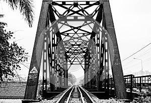 A black and white photo of a railway track on a steel bridge in Taling Chan district, Bangkok.