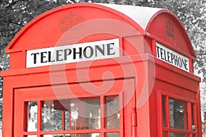 Black and white photo with red telephone booth in classic english style