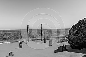 Black and white photo of remains of an old pier