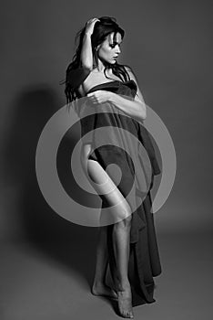 Black and white photo of a seductive brunette girl in studio. topless woman. Monochrome image.