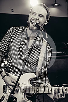 Black and white photo of singing guitarist
