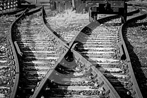 Black and white photo of some old rails crossing