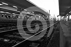 Black and white photo of train tracks in the station