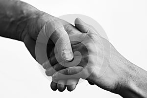 Black and white photo. Two hands lend a helping hand to a friend.