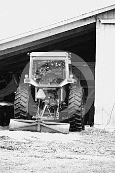 Black and White Photo of a White tractor annd scrapper blade