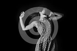 Black white photo of the woman whit long hair in a summer dress on a black background