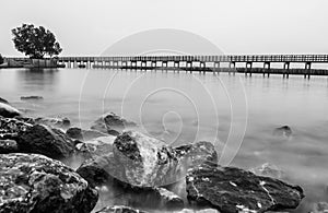 Black and white photo of the wooden bridge along the beach