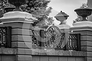 Black and white photo of a wrought iron fence in the park