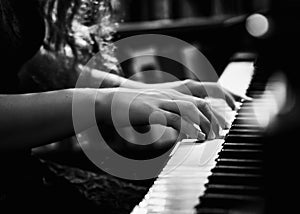 Black and White Photo of Young Lady Playing the Piano