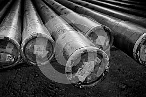 Black and white photograph of drilling pipe for an oil rig