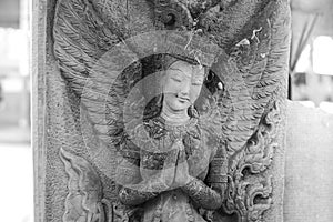 Black and white photograph of light and shadow on a stucco artwork of an angel