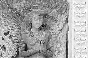 Black and white photograph of light and shadow on a stucco artwork of an angel