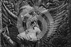 Black and white photograph of light and shadow on a stucco artwork of an angel