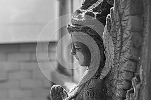 Black and white photograph of light and shadow on a stucco artwork of an angel
