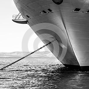 black and white photograph of a ship at the beach with a dock