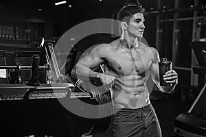 A black-and-white photograph of a young bodybuilder athlete in t