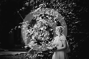 Black white photography beautiful young bride stand on background forest