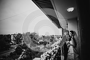 Black white photography beautiful young couple stand on the balcony