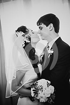 Black white photography beautiful young couple standing near the window