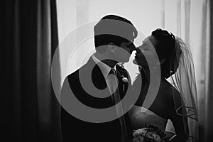 Black white photography beautiful young couple standing near the window