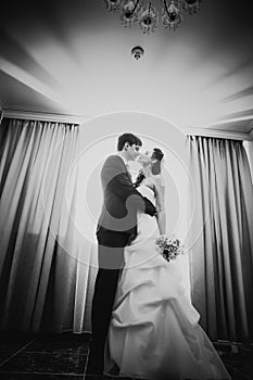 Black white photography beautiful young couple standing near the window