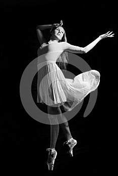 Black and white photography of beautiful young woman in dancing on dark background copyspace