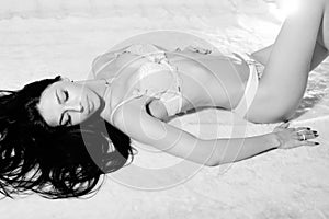 Black and white photography of beautiful young woman lying on bed in underwear having relaxation dreaming