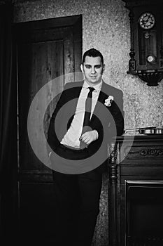 Black white photography elegance groom is posing on the background room