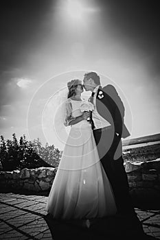 Black white photography happy couple bride and groom embracing they stand on background