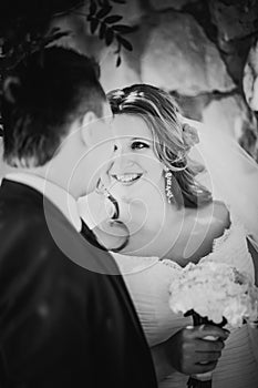 Black white photography happy couple bride and groom embracing they stand on background