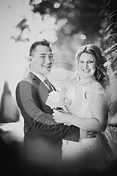 Black white photography happy couple bride and groom embracing they stand on background