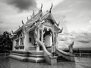 Black and white photography with little buddhist white temple with nobody and dramatic cloudy sky in dark atmosphere