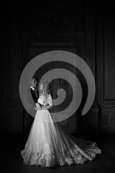 Black and white photography. Luxury wedding couple in love. Beautiful bride in white dress with brides bouquet and