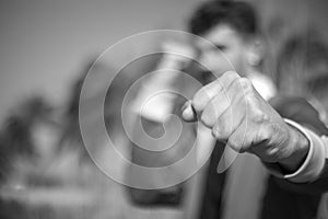 Black and white photography of a man fist punching isolated in a exterior location