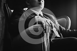 Black white photography portrait of man in black classic suit on a dark background.