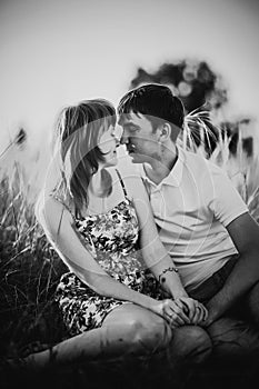 Black white photography romantic couple standing and kissing on background summer meadow