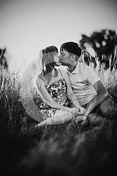 Black white photography romantic couple standing and kissing on background summer meadow