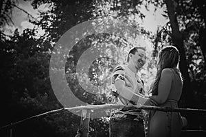 Black white photography romantic young couple kissing and stand to bridge on background