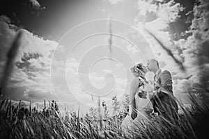 Black white photography wedding beautiful young couple kissing on the background of mead