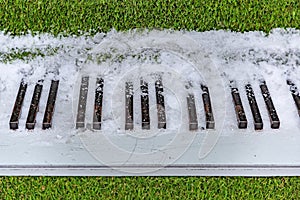 Black and white piano keys with grass and snow