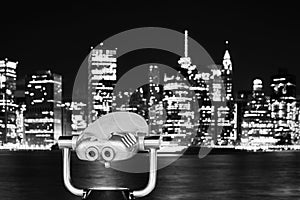 Binoculars pointed at Manhattan skyline at night, NYC.