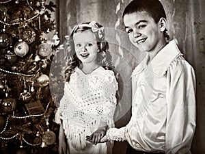 Black and white picture children under Christmas tree.