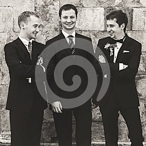 A black and white picture of groom posing with his friends