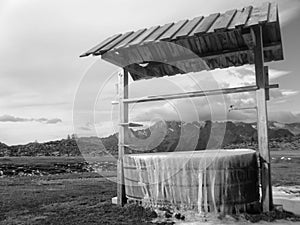 black and white picture of a iced fountain in the mountain