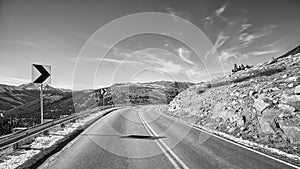 Black and white picture of a mountain road turn