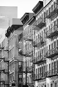 Black and white picture of New York cityscape with old buildings with fire escapes, USA