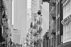 Black and white picture of New York cityscape with old buildings with iron fire escapes, USA